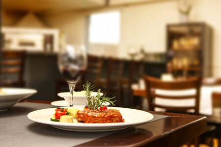 steak with tomato on a white plate in a restaurant