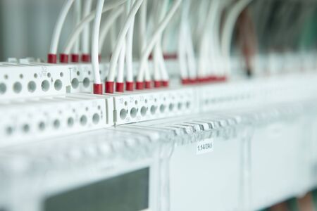 electric working on a clean modern switchboard with white cablesの写真素材