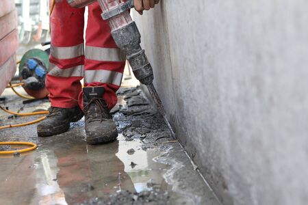 Hard working people at construction site. With orange working pantsの写真素材