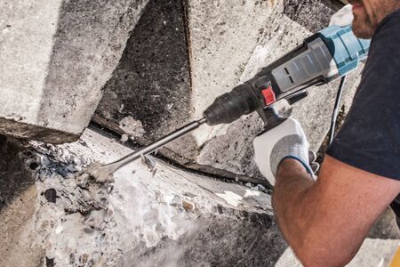 power chisel splinter off rocks and stones with arm and hands showingの写真素材