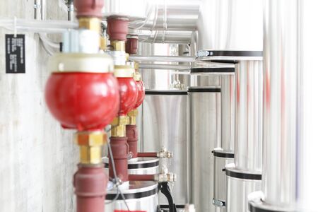 chrome pipes in heating and AC rooms in buildings of factories and hospital. Several pipes with silver pipes and red connectorの写真素材