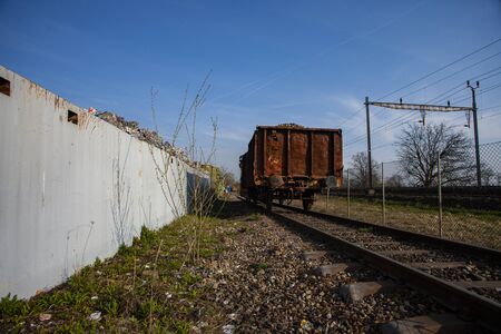rusty railroad car waiting at recycle station with blue skyの写真素材