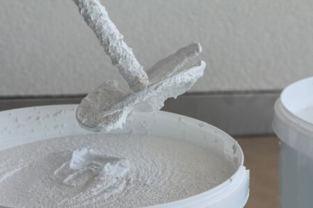 Plasterer stirring plaster in a bucket, White colorの写真素材