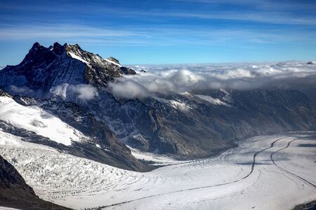 Three famous Swiss mountain peaks, Eiger, MÃ¶nch and Jungfrau, With clouds and snow