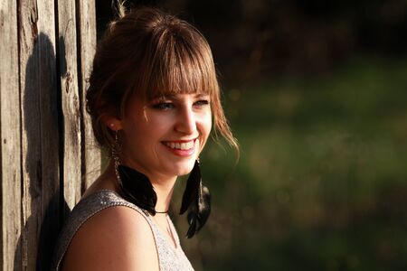 beautiful blond female model in Boho Style shooting outdoors on wooden house and stairsの写真素材