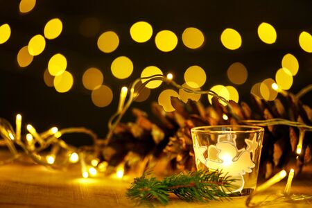 christmas theme with candles, snow, pine cone and christmas light with pokeh effectの写真素材