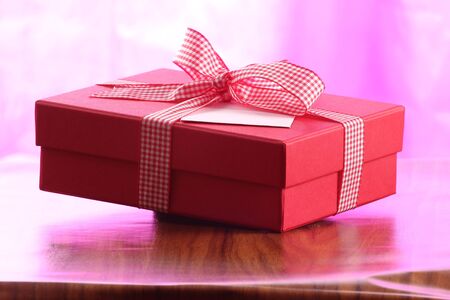 red christmas present with ribbon. Presents in a table with decoration and copy space and a ribbonの写真素材