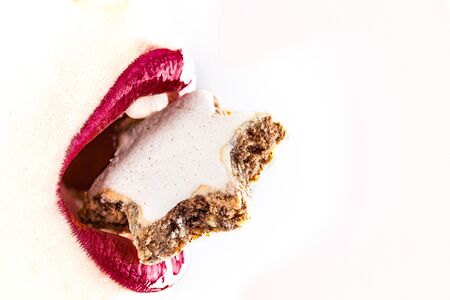 woman red lips eating tasty food with star cookieの写真素材