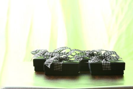 Presents on a table with a bow. Background space for copy. For Christmas, birthday or other holiday cardsの写真素材