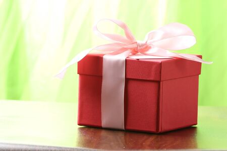 Presents on a table with a bow. Background space for copy. For Christmas, birthday or other holiday cardsの写真素材