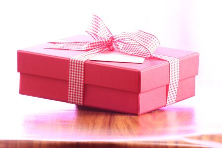 Presents on a table with a bow. Background space for copy. For Christmas, birthday or other holiday cardsの写真素材