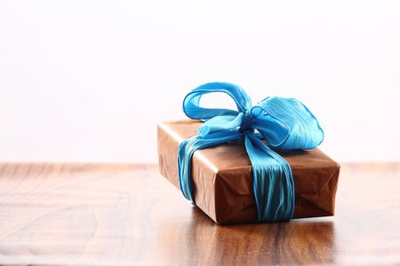 Presents on a table with a bow. Background space for copy. For Christmas, birthday or other holiday cardsの写真素材