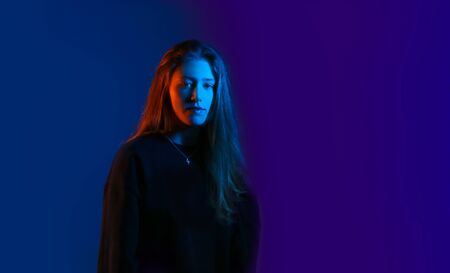 pretty teenage model in studio with blue and orange light. Model enjoying a photo shoot