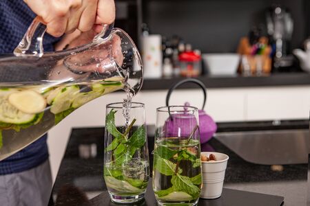 fresh drink prepared with water by a cook with hands