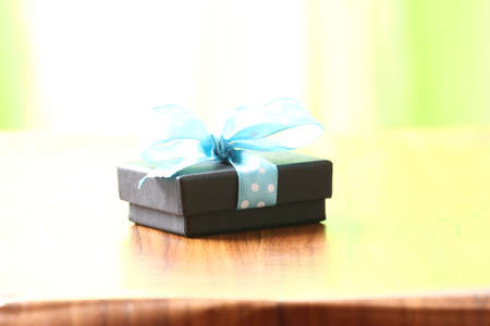 Presents on a table with a bow. Background space for copy. For Christmas, birthday or other holiday cardsの写真素材