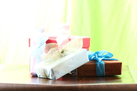 Presents on a table with a bow. Background space for copy. For Christmas, birthday or other holiday cardsの写真素材