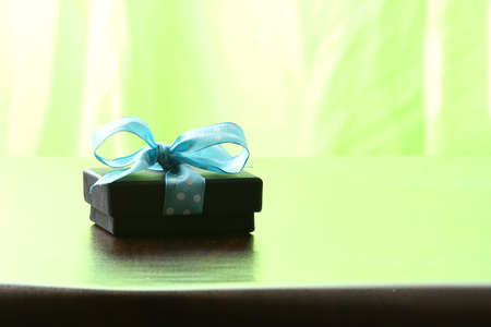 Presents on a table with a bow. Background space for copy. For Christmas, birthday or other holiday cardsの写真素材