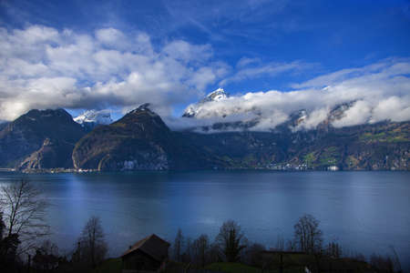 clouds and mountains with a lake in foreground near Brunnen in Switzerlandの写真素材
