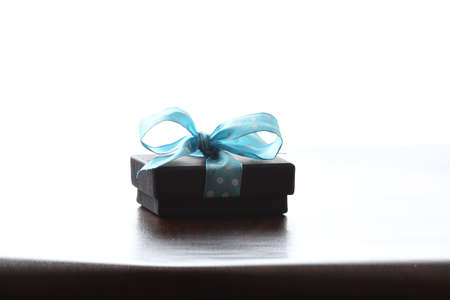 Presents on a table with a bow. Background space for copy. For Christmas, birthday or other holiday cardsの写真素材