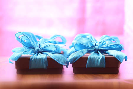 Presents on a table with a bow. Background space for copy. For Christmas, birthday or other holiday cardsの写真素材