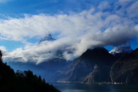 clouds and mountains with a lake in foreground near Brunnen in Switzerlandの写真素材
