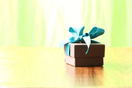 Presents on a table with a bow. Background space for copy. For Christmas, birthday or other holiday cardsの写真素材