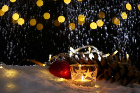 christmas theme with candles, snow, pine cone and christmas light with pokeh effectの写真素材