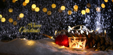 christmas theme with candles, snow, pine cone and christmas light with pokeh effectの写真素材