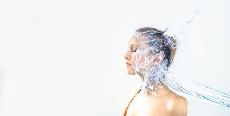 pretty woman with water splash. Beautiful model woman with a splash of water. Beautiful smiling girl underwater with fresh skin on blue background. Skin care, cleansing and moisturizing concept. Pretty faceの写真素材