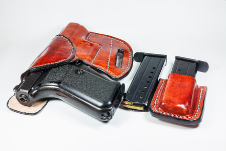9 mm handgun in a leather holster isolated on white の写真素材