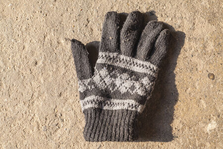 Old Knit Gloves with Pattern on concrete floorの写真素材