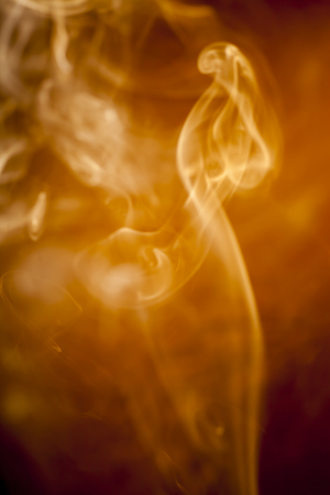 Golden smoke on black backgroundの写真素材