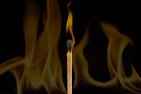 Matchstick burning  on  fire background.