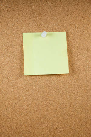 Yellow note papers on cork board background.の写真素材