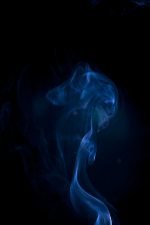 Blue smoke on black background.の写真素材