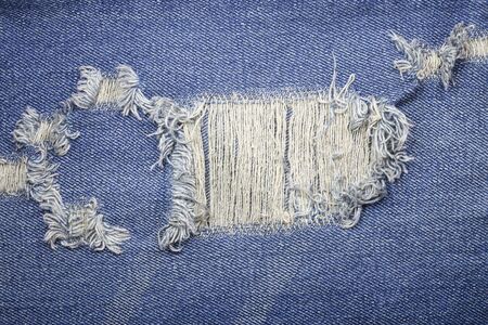 Blue torn denim jeans texture.