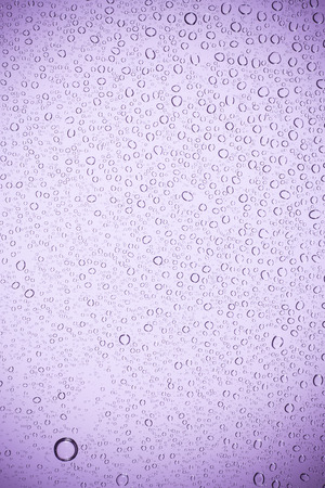 Purple glass have a water drops.の写真素材