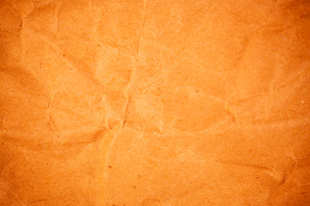 Textured crumpled packaging orange paper background.の写真素材
