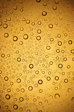Yellow water droplets background.の写真素材