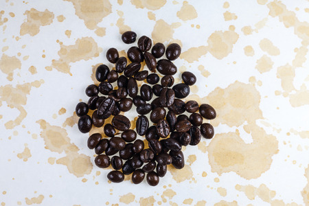 Coffee beans and coffee stains on a white tablecloth.の写真素材