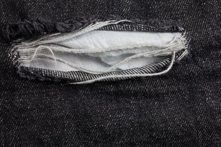 Old black jeans torn denim texture vintage.