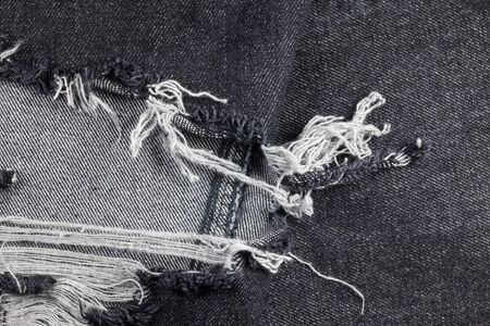 Old black jeans torn denim texture vintage.