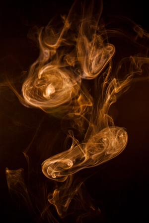 Golden smoke on black background.の写真素材