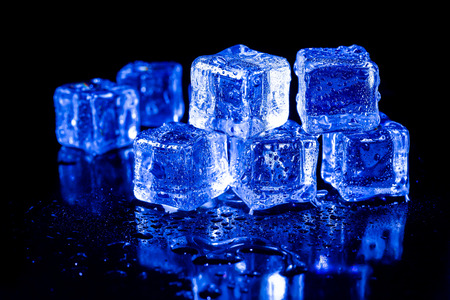 ice cubes in blue light on a black table.の写真素材