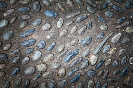 cobblestones in concrete background, Round stones in the ground.