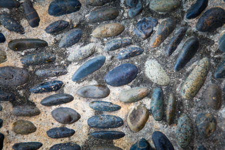 cobblestones in concrete background, Round stones in the ground.の写真素材
