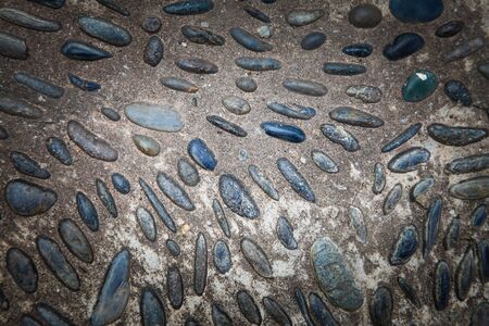 cobblestones in concrete background, Round stones in the ground.の写真素材