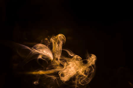 Gold smoke movement on black background.の写真素材