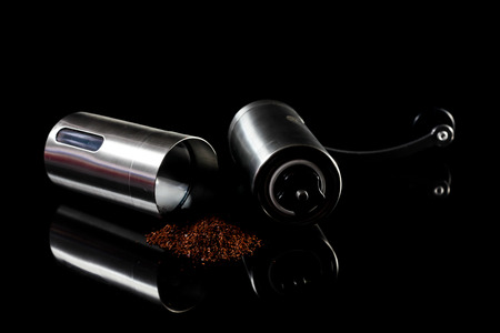 Freshly ground coffee beans with grinder.