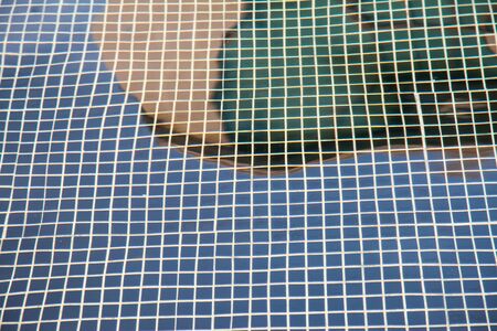 Patterns mosaic tile background in swimming pool.